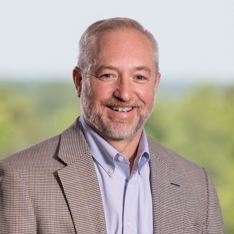 Headshot of Michael Panasko with graying hair and a dark suit jacket.