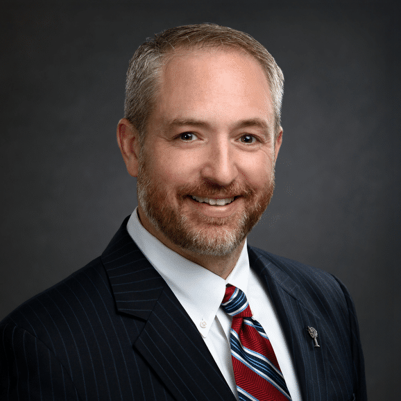 Headshot of Michael Panasko with graying hair and a dark suit jacket.